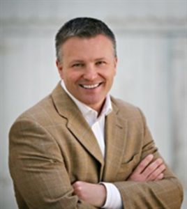 A photo of a smiling Dr. James Chestnut in a tan sport coat